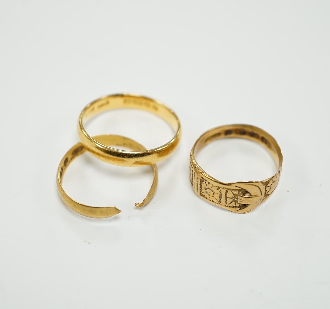 Two 22ct gold wedding bands (one cut), 5.8 grams and an 18ct gold buckle ring, 2.9 grams.